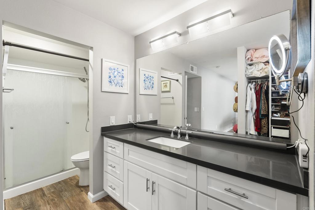 18027 Cotorro Road San Diego, CA 92128 - Photo 22 of 31 a bathroom with a granite countertop sink a toilet and a mirror