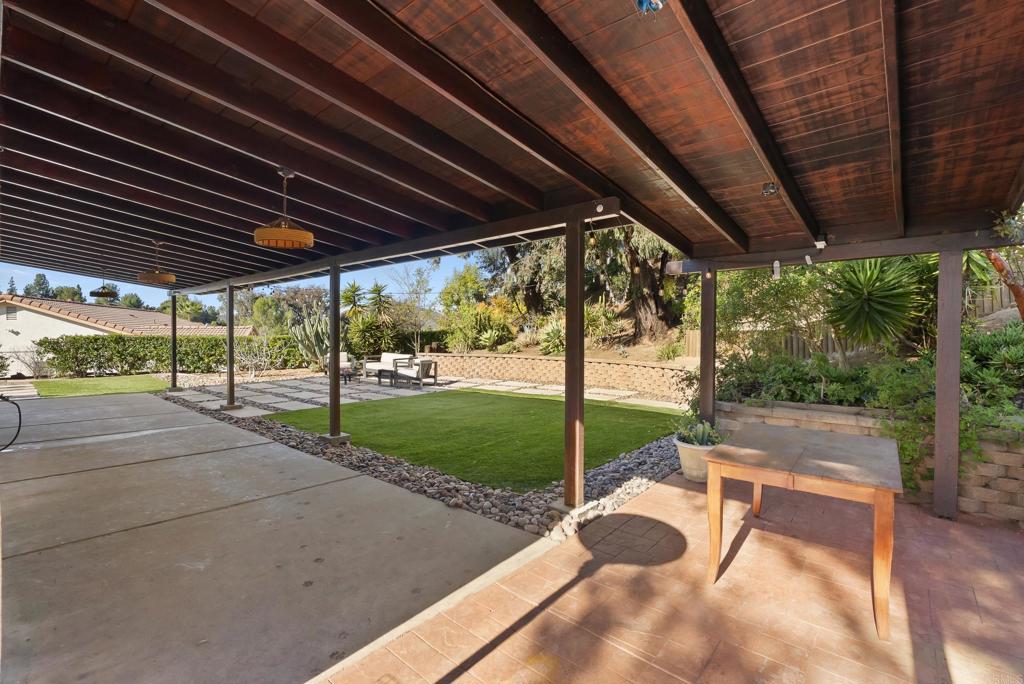 18027 Cotorro Road San Diego, CA 92128 - Photo 24 of 31 a view of a backyard with table and chairs under an umbrella