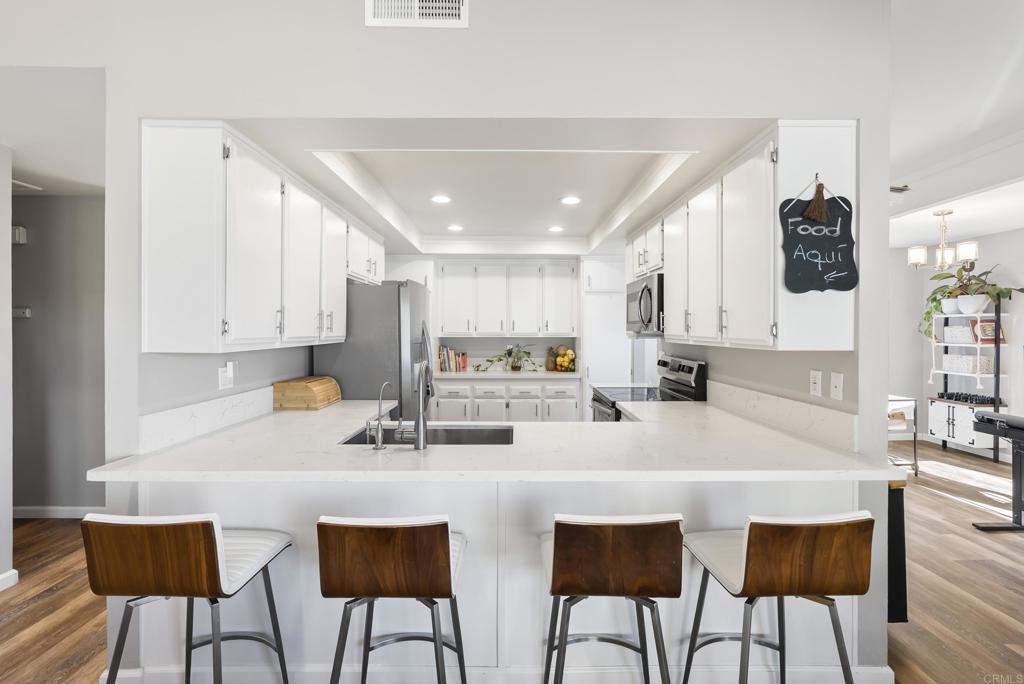 18027 Cotorro Road San Diego, CA 92128 - Photo 8 of 31 a kitchen with stainless steel appliances a table and chairs in it