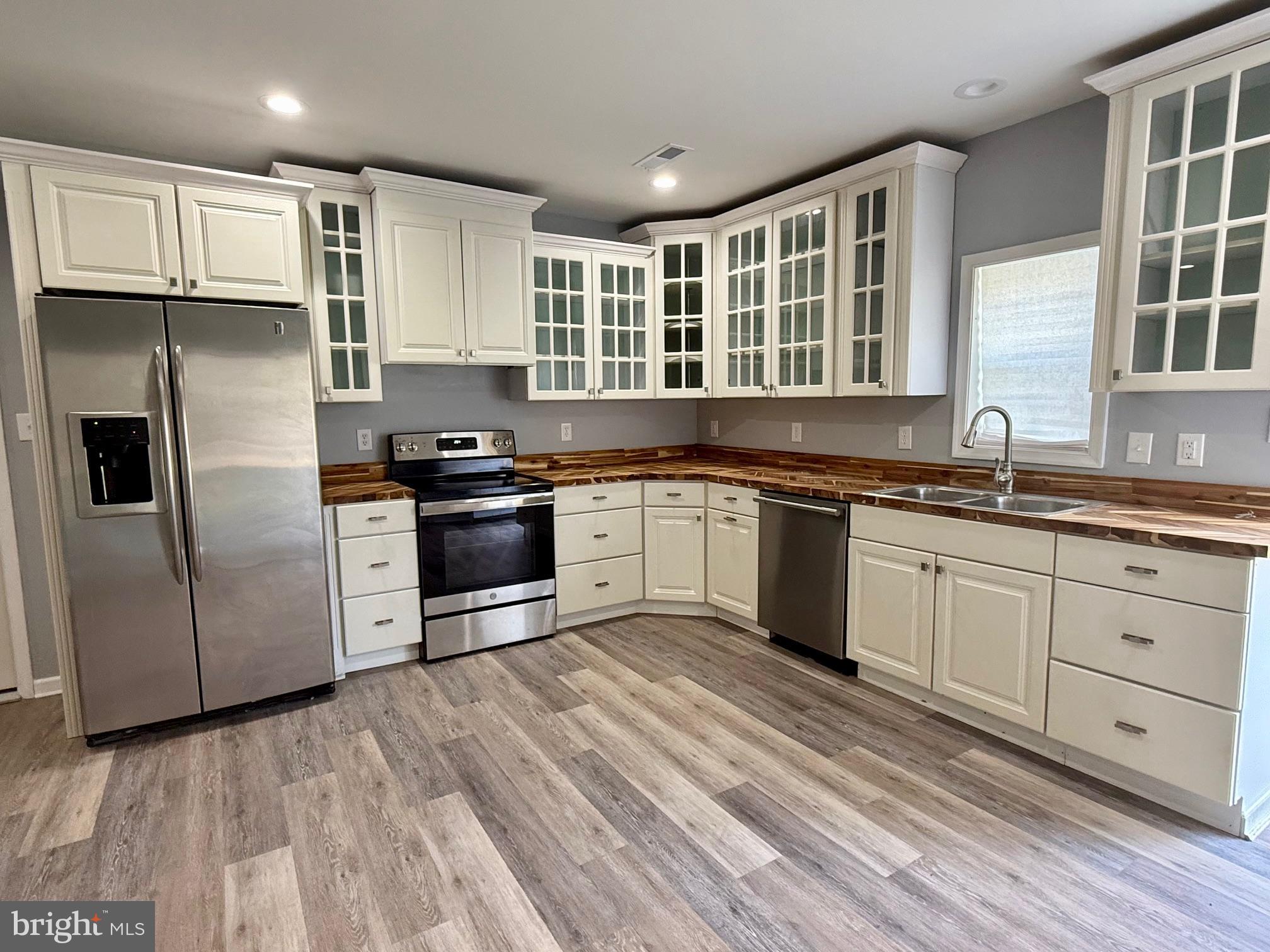 a kitchen with granite countertop a sink stainless steel appliances and cabinets