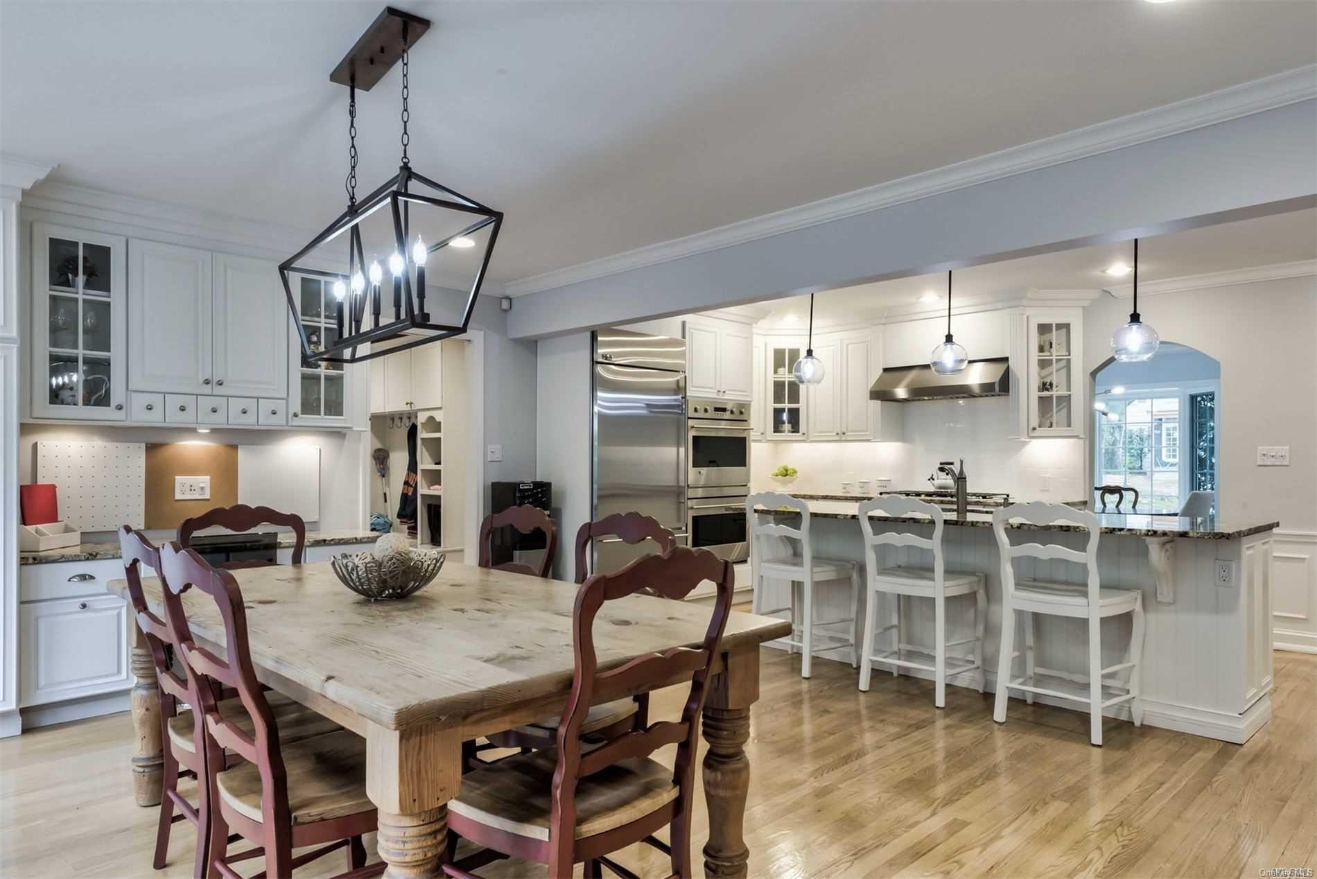 67 Longridge Road Manhasset, NY 11030 - Photo 1 of 1 a dining room with furniture a chandelier and wooden floor