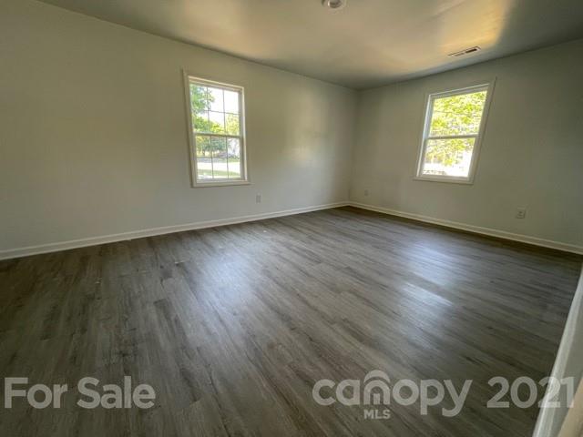 315 South Ransom Street Gastonia, NC 28052 - Photo 11 of 20 an empty room with wooden floor and windows