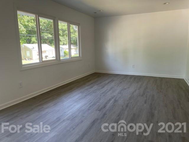 315 South Ransom Street Gastonia, NC 28052 - Photo 12 of 20 an empty room with wooden floor and windows