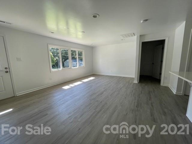 315 South Ransom Street Gastonia, NC 28052 - Photo 5 of 20 an empty room with wooden floor and window