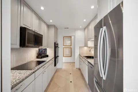 a kitchen with stainless steel appliances granite countertop a refrigerator and a sink