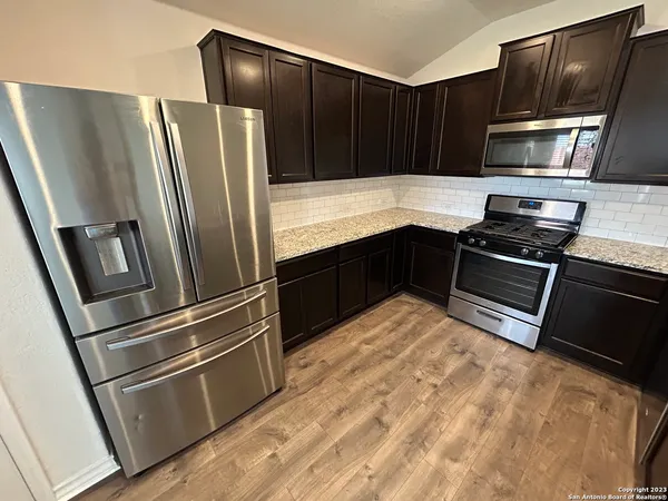a kitchen with granite countertop stainless steel appliances and wooden cabinets