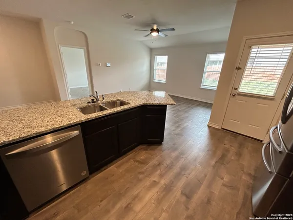 a kitchen with a sink and a wooden floor