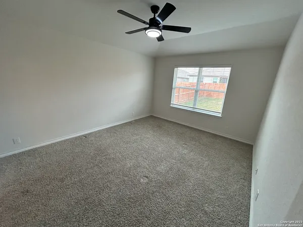 an empty room with windows and fan