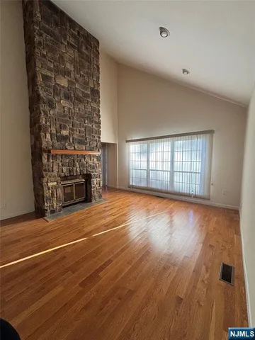 an empty room with wooden floor and fireplace