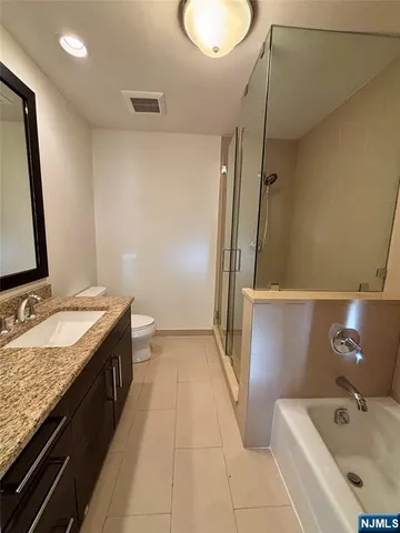 a bathroom with a tub sink and mirror