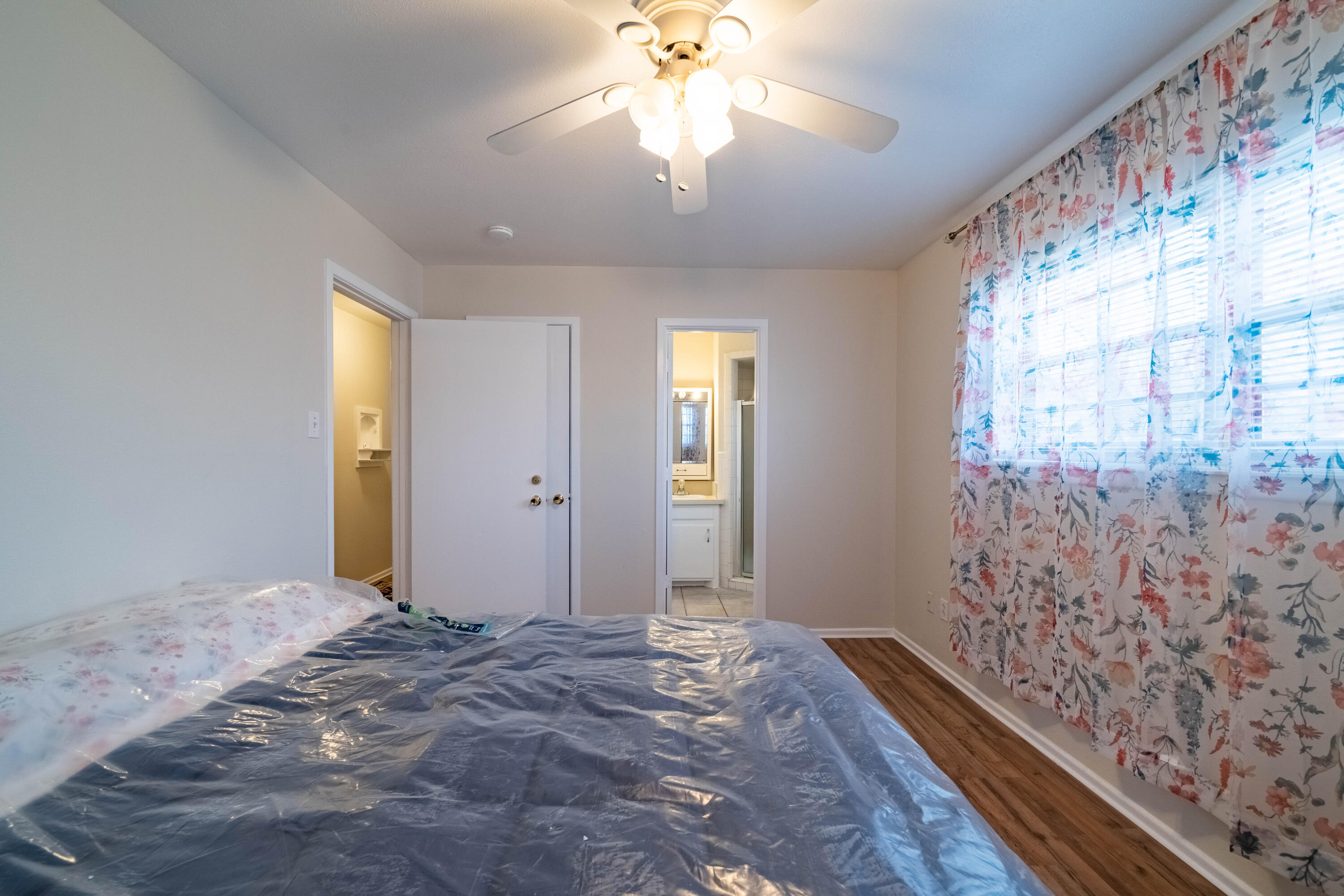 5202 47th Street Lubbock, TX 79414 - Photo 6 of 15 a view of a hallway with a chandelier fan and wooden floor