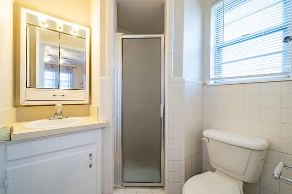 a bathroom with a toilet sink vanity and mirror