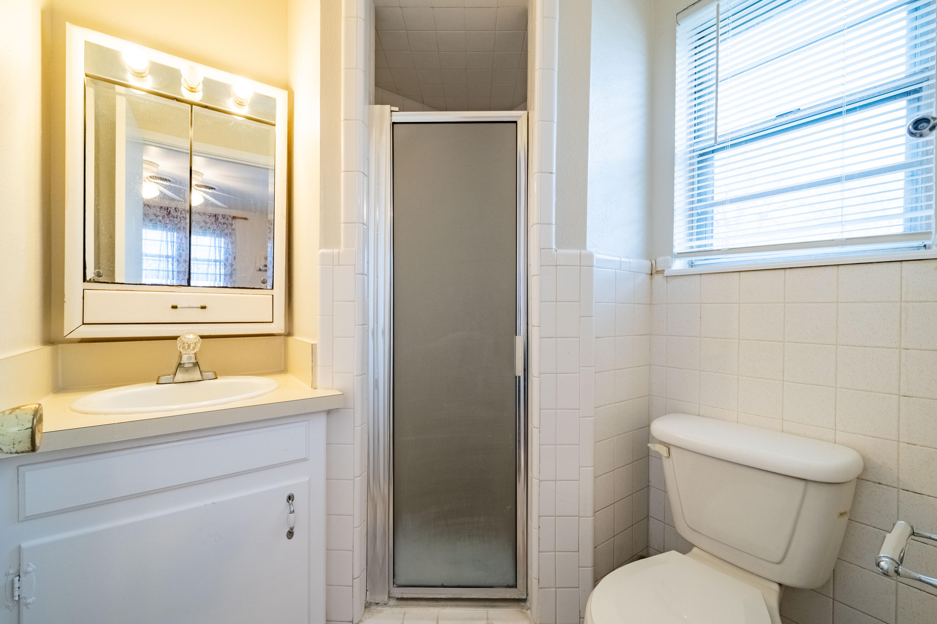 5202 47th Street Lubbock, TX 79414 - Photo 8 of 15 a bathroom with a toilet sink vanity and mirror
