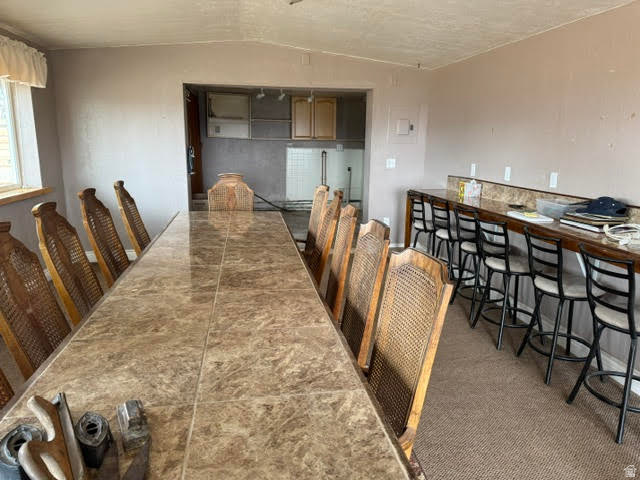 1124 Washam Road Green River, WY 82938 - Photo 17 of 35 Spacious room featuring a long tiled table, a built-in bar with stone-finish countertop, and integrated cabinetry