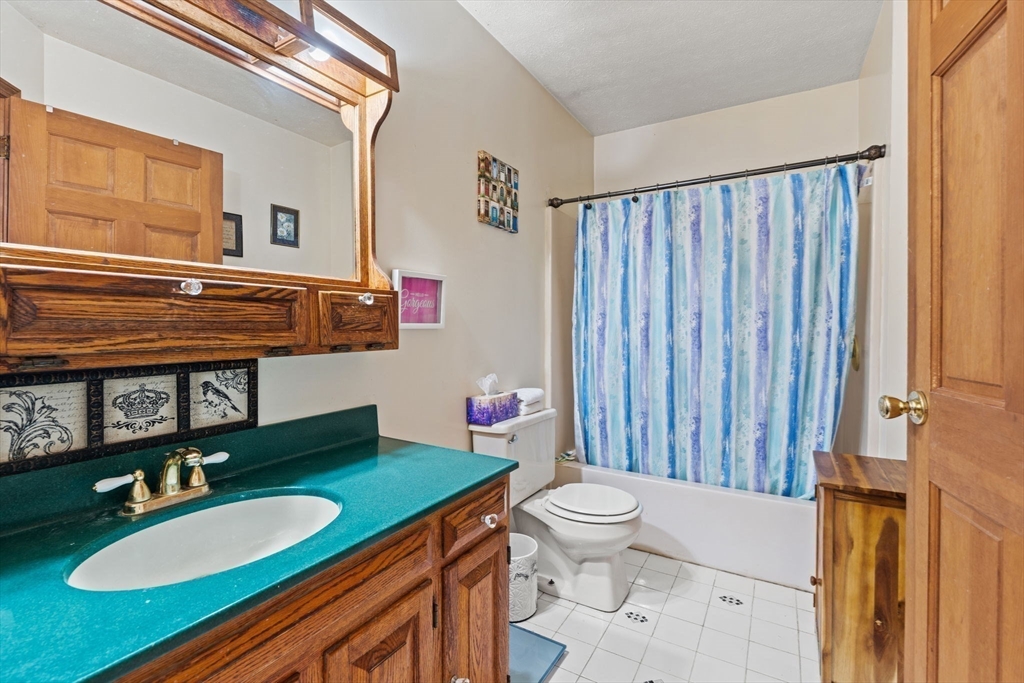 103 Renshaw Road Weare, NH 03281 - Photo 29 of 42 a bathroom with a granite countertop toilet a sink and a mirror