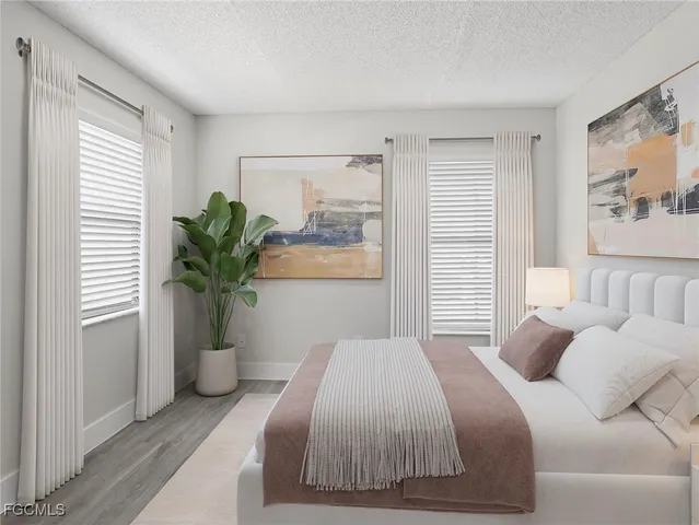 a bedroom with a large bed and a potted plant