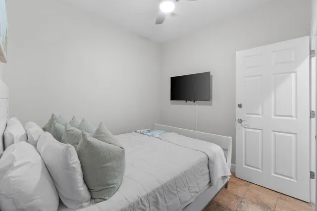 a bedroom with a bed and a flat tv screen on wall