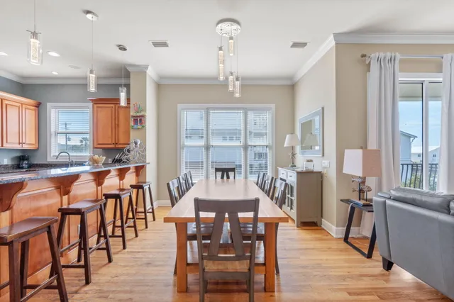 a kitchen with stainless steel appliances granite countertop a stove a sink and a refrigerator with wooden floors