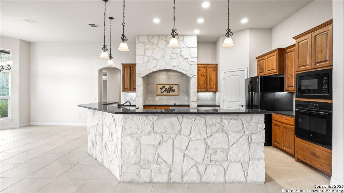 8018 Canham Ranch Garden Ridge, TX 78266 - Photo 12 of 51 a kitchen with stainless steel appliances granite countertop a sink a stove and a refrigerator