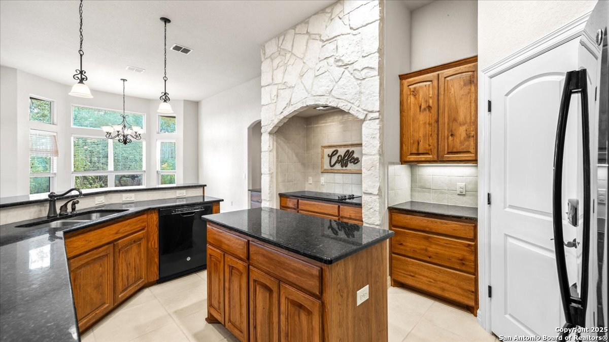 8018 Canham Ranch Garden Ridge, TX 78266 - Photo 13 of 51 a kitchen with granite countertop a sink and a refrigerator