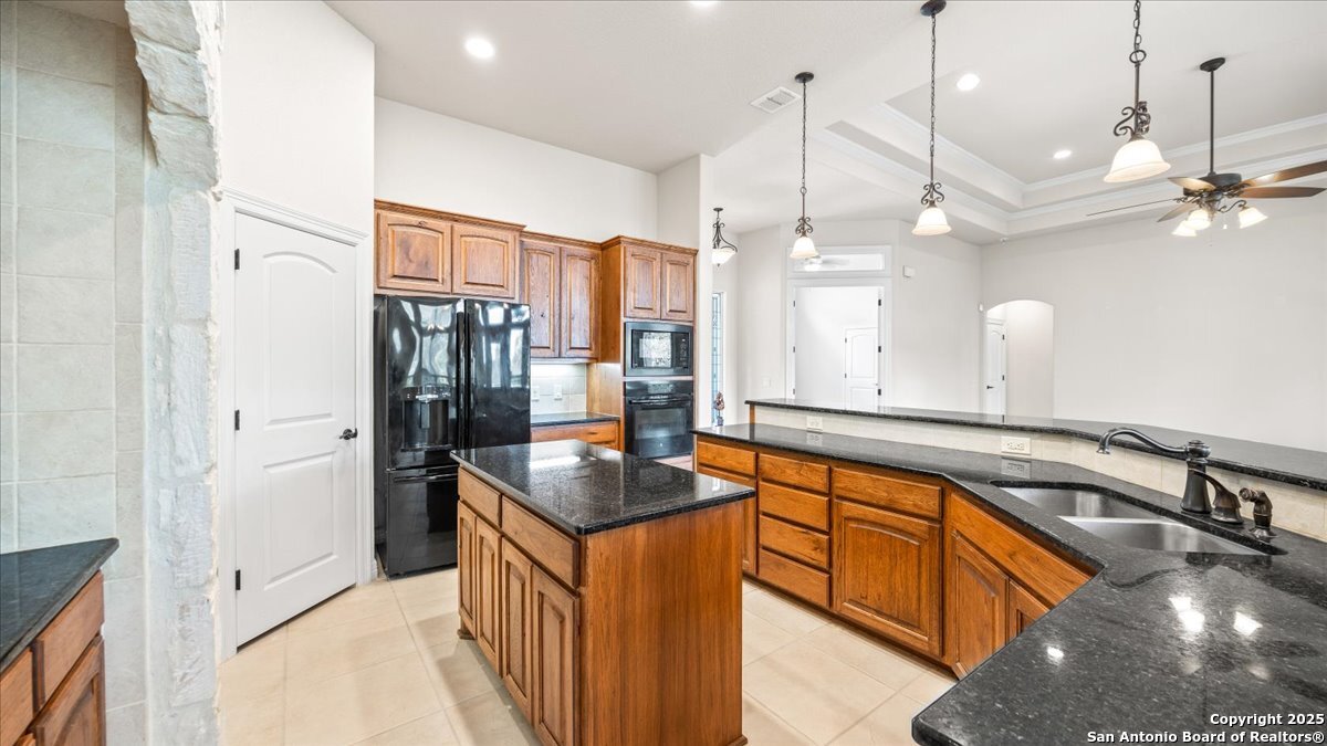 8018 Canham Ranch Garden Ridge, TX 78266 - Photo 14 of 51 a kitchen with stainless steel appliances granite countertop a sink a counter space and a refrigerator