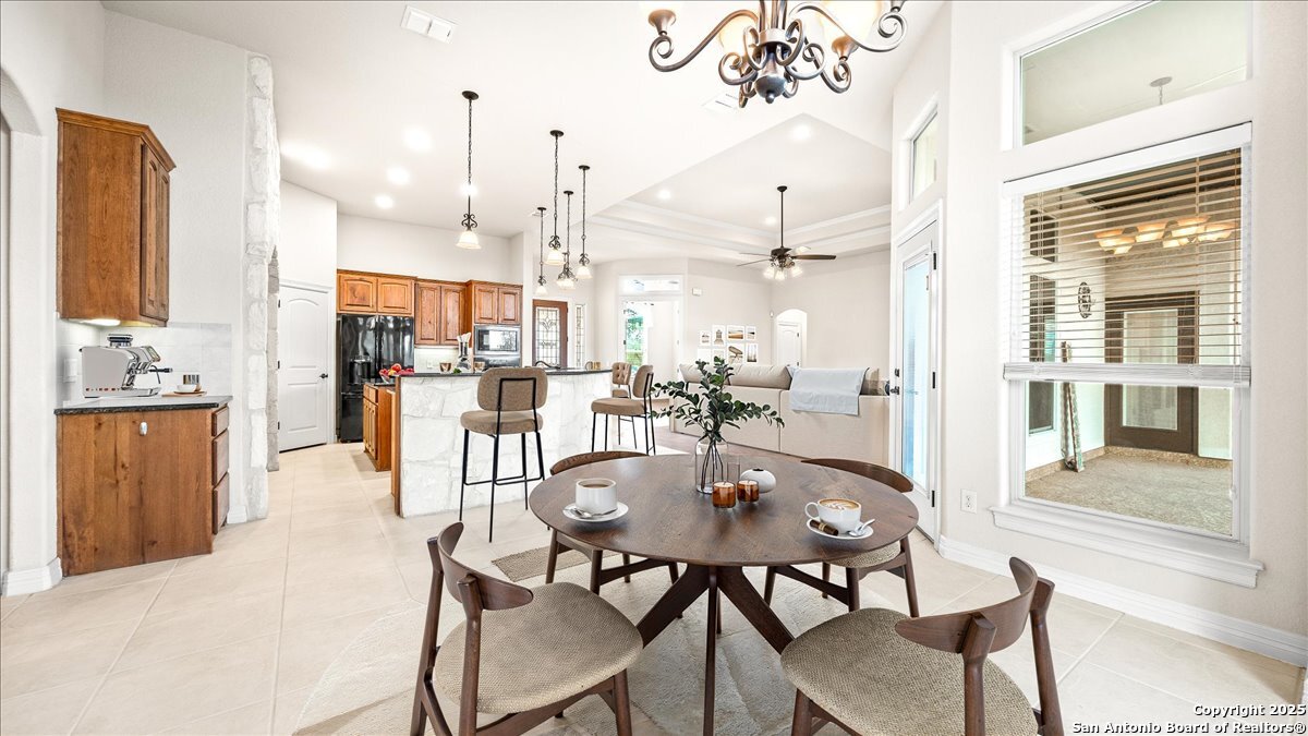 8018 Canham Ranch Garden Ridge, TX 78266 - Photo 18 of 51 a dining room filled with furniture and a chandelier