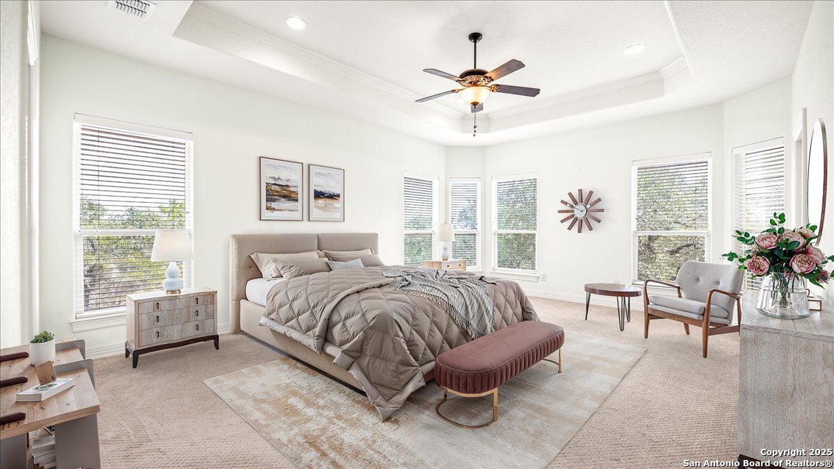 8018 Canham Ranch Garden Ridge, TX 78266 - Photo 20 of 51 a spacious bedroom with a bed a chandelier and a window