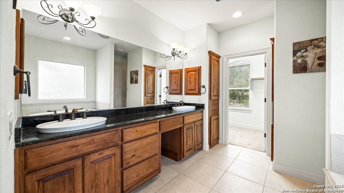 8018 Canham Ranch Garden Ridge, TX 78266 - Photo 22 of 51 a spacious bathroom with a granite countertop sink mirror and a