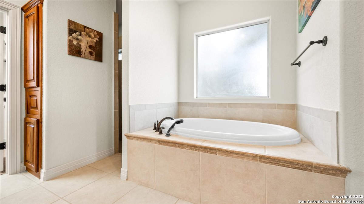 8018 Canham Ranch Garden Ridge, TX 78266 - Photo 23 of 51 a bathroom with a bathtub and a window