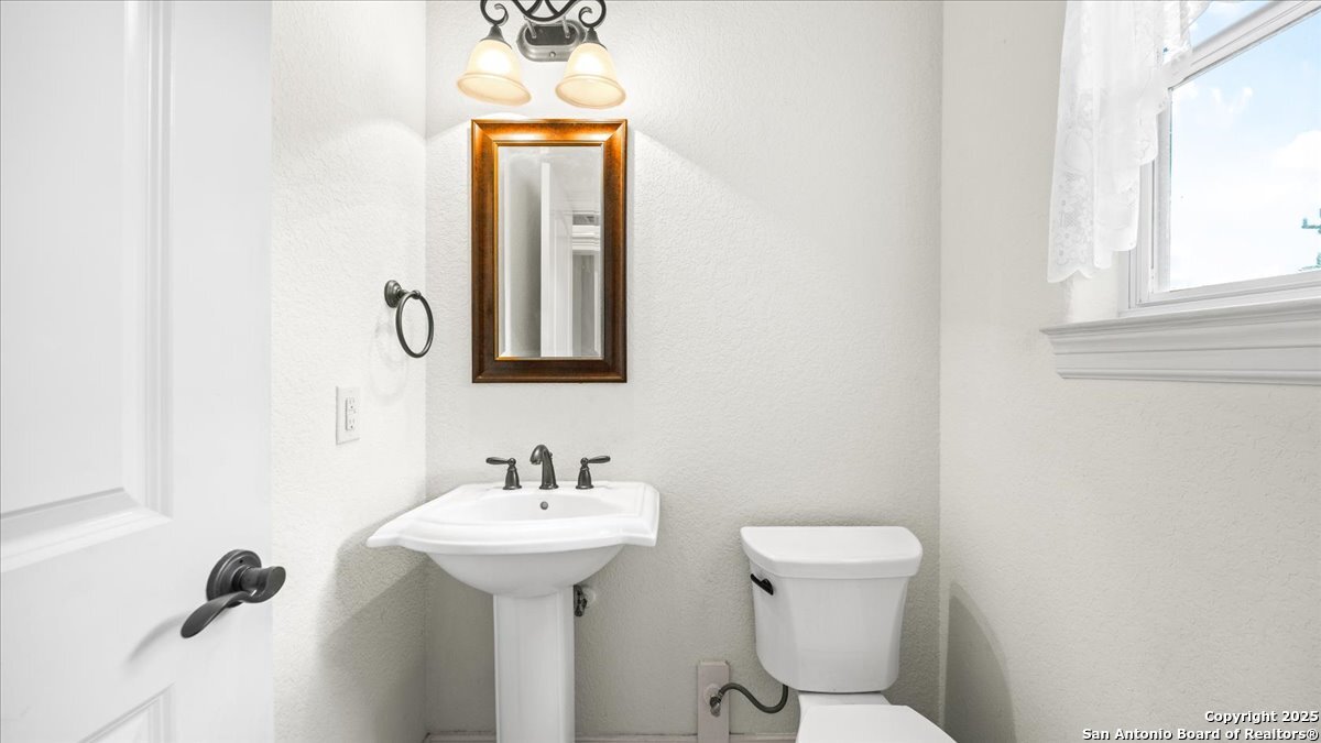 8018 Canham Ranch Garden Ridge, TX 78266 - Photo 31 of 51 a bathroom with a sink a toilet and mirror