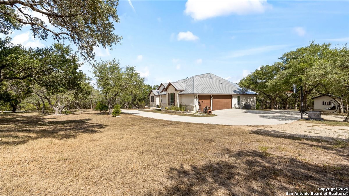 8018 Canham Ranch Garden Ridge, TX 78266 - Photo 43 of 51 a view of a house with a yard and a large tree