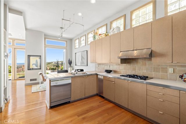a kitchen with white cabinets appliances and a window
