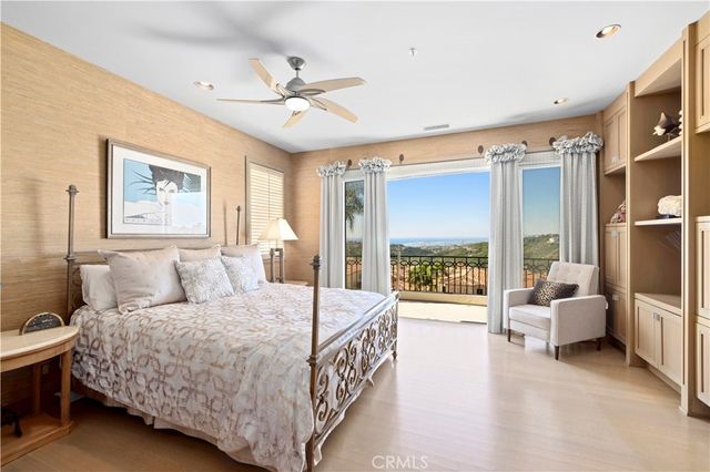 a bedroom with a large bed and a chandelier