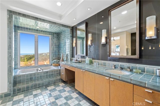 a bathroom with a granite countertop sink mirror and a bath tub