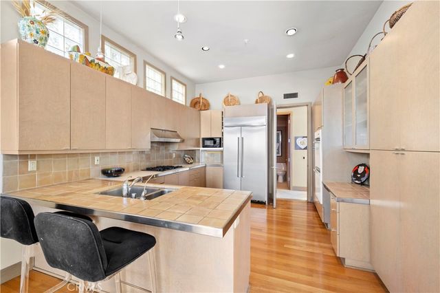 a kitchen with a sink a refrigerator and a stove top oven