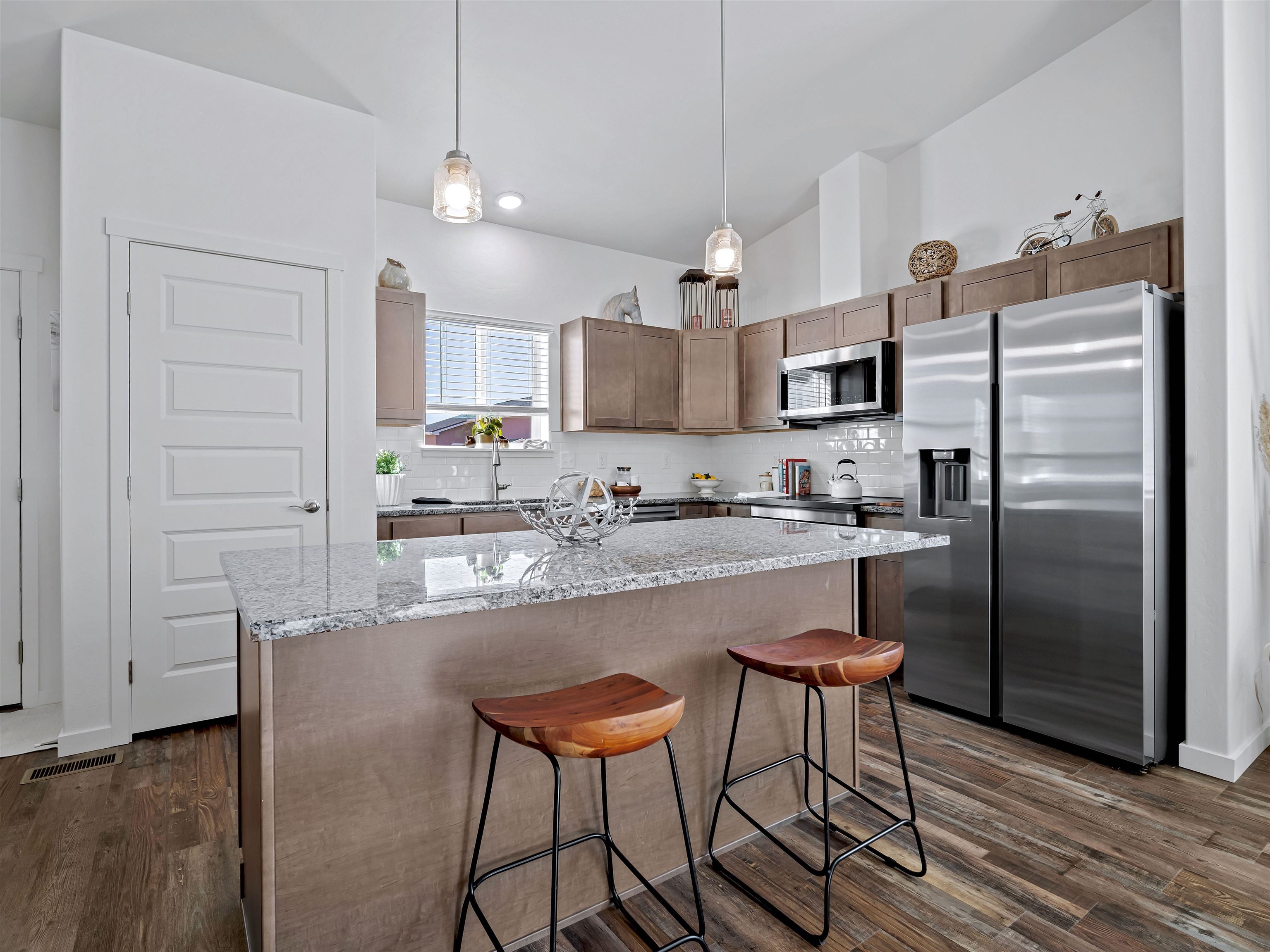 2147 Moon River Road Grand Junction, CO 81505 - Photo 11 of 34 a kitchen with stainless steel appliances granite countertop a refrigerator a stove a sink and white cabinets with wooden floor