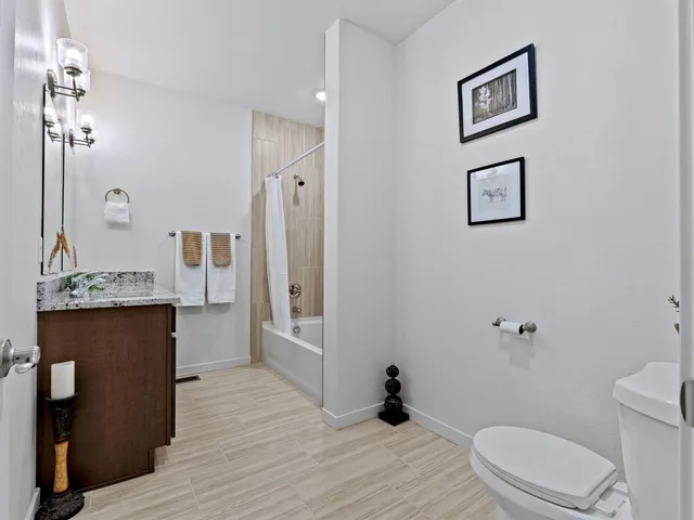 a bathroom with a granite countertop sink toilet a mirror and shower