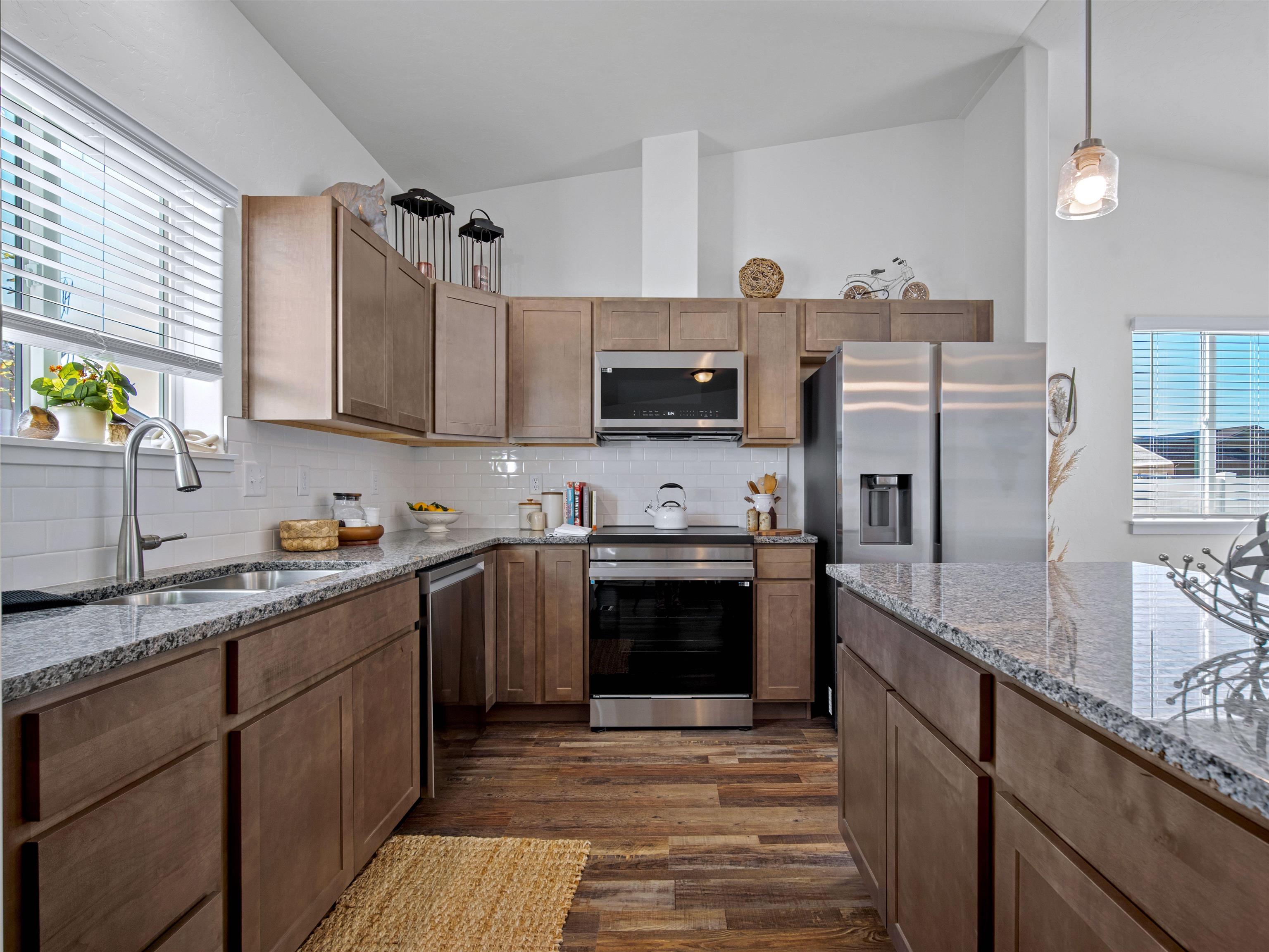 2147 Moon River Road Grand Junction, CO 81505 - Photo 7 of 34 a kitchen with stainless steel appliances granite countertop a sink stove microwave and refrigerator