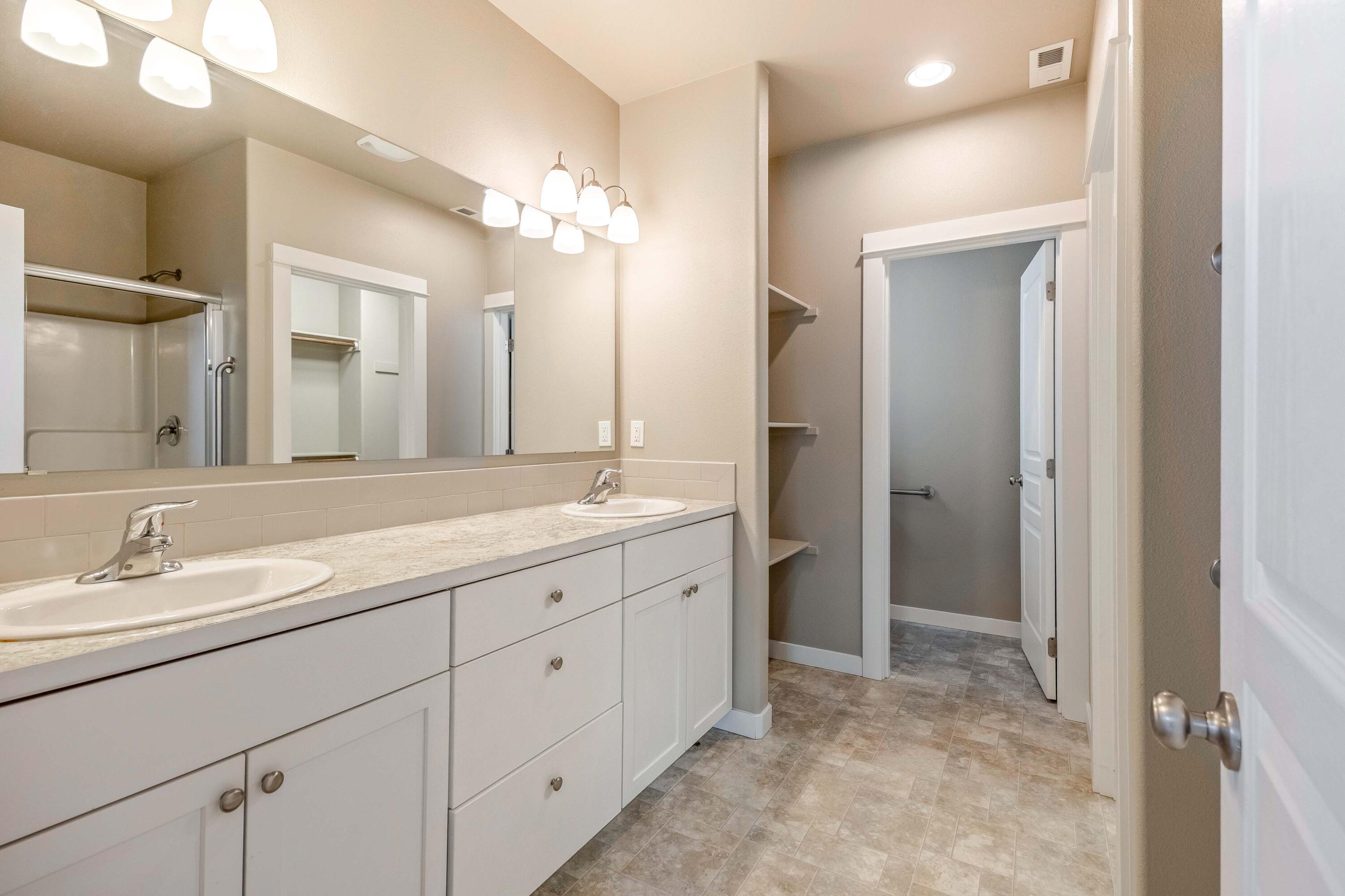 2510 Northwest Hemlock Way Redmond, OR 97756 - Photo 13 of 32 a spacious bathroom with a granite countertop sink a mirror and a shower