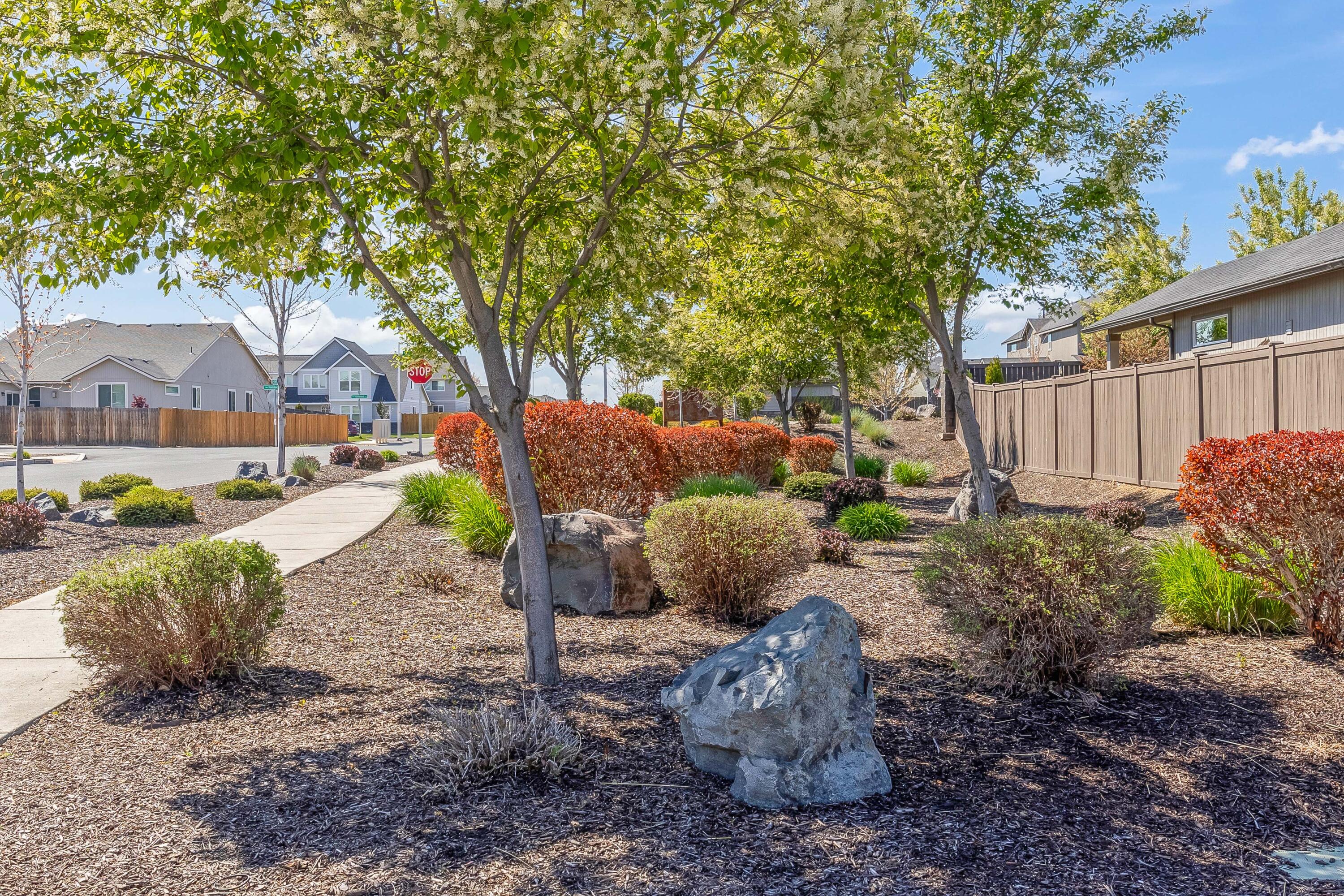 2510 Northwest Hemlock Way Redmond, OR 97756 - Photo 27 of 32 a view of a backyard with table and chairs potted plants and large tree