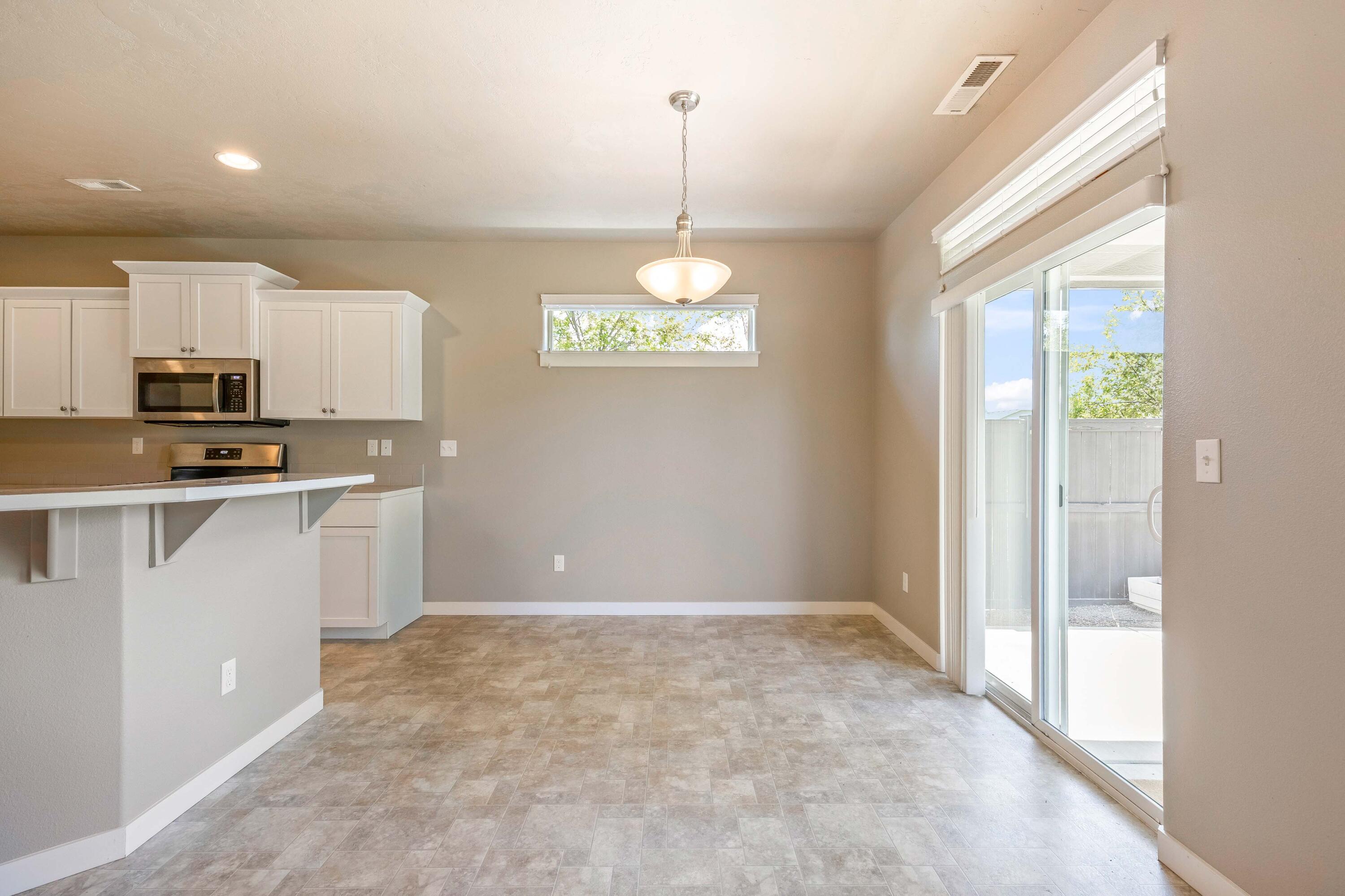 2510 Northwest Hemlock Way Redmond, OR 97756 - Photo 7 of 32 a kitchen with kitchen island granite countertop a stove a refrigerator a sink a microwave and island