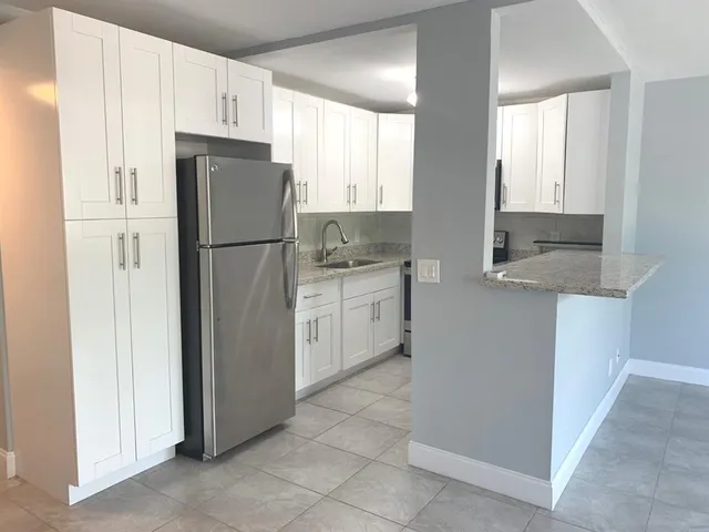 a kitchen with a refrigerator sink and cabinets