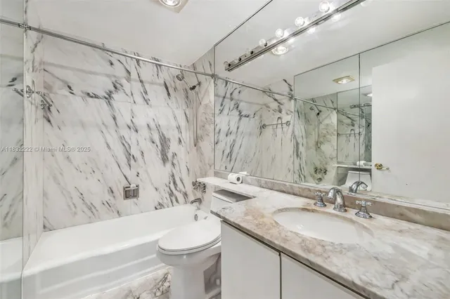 a bathroom with a granite countertop sink a toilet and a bathtub