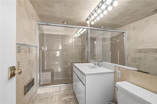 a bathroom with a sink a toilet and shower