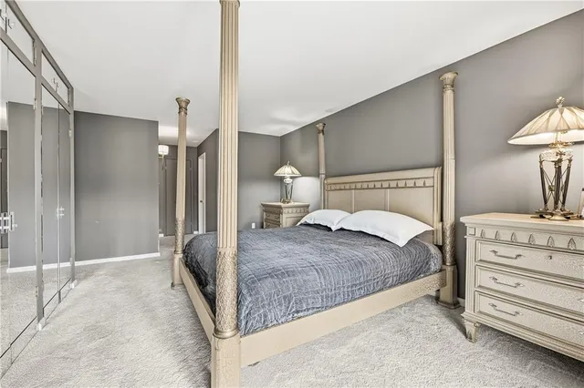 a spacious bedroom with a bed and a lamp