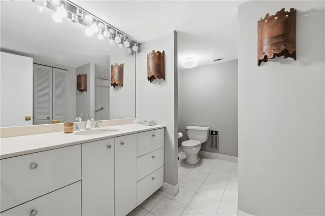 a bathroom with a double vanity sink toilet and mirror