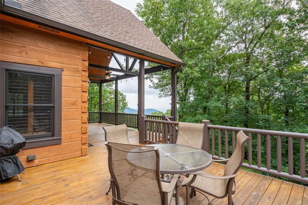 31 High Cliff Road Jasper, GA 30143 - Photo 31 of 50 a patio with wooden floor a yard a table and chairs