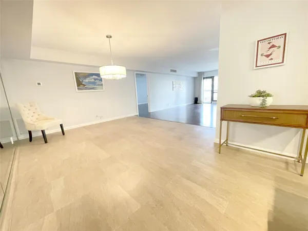 a living room with stainless steel appliances kitchen island granite countertop furniture and a wooden floor