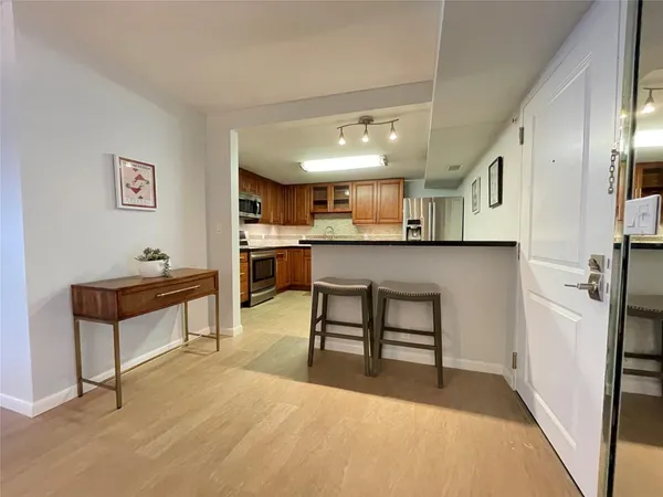 a kitchen with stainless steel appliances granite countertop a refrigerator a stove top oven a sink dishwasher and a refrigerator