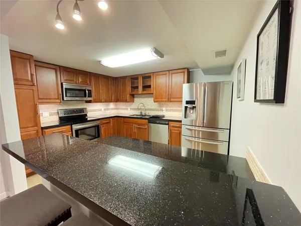 a kitchen with stainless steel appliances granite countertop a stove top oven a sink and dishwasher